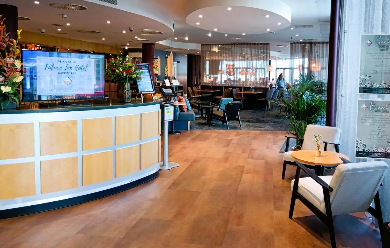a restaurant with a bar and tables and chairs at Future Inn Cardiff Bay in Cardiff