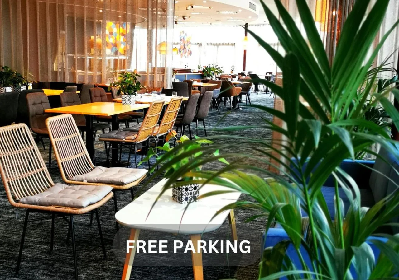 a restaurant with tables and chairs and a potted plant at Future Inn Cardiff Bay in Cardiff
