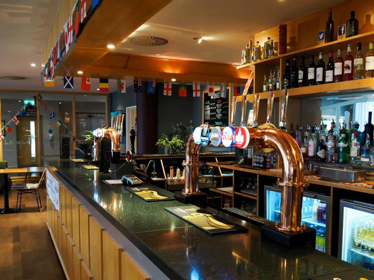 a bar with two faucets on top of a counter at Future Inn Cardiff Bay in Cardiff