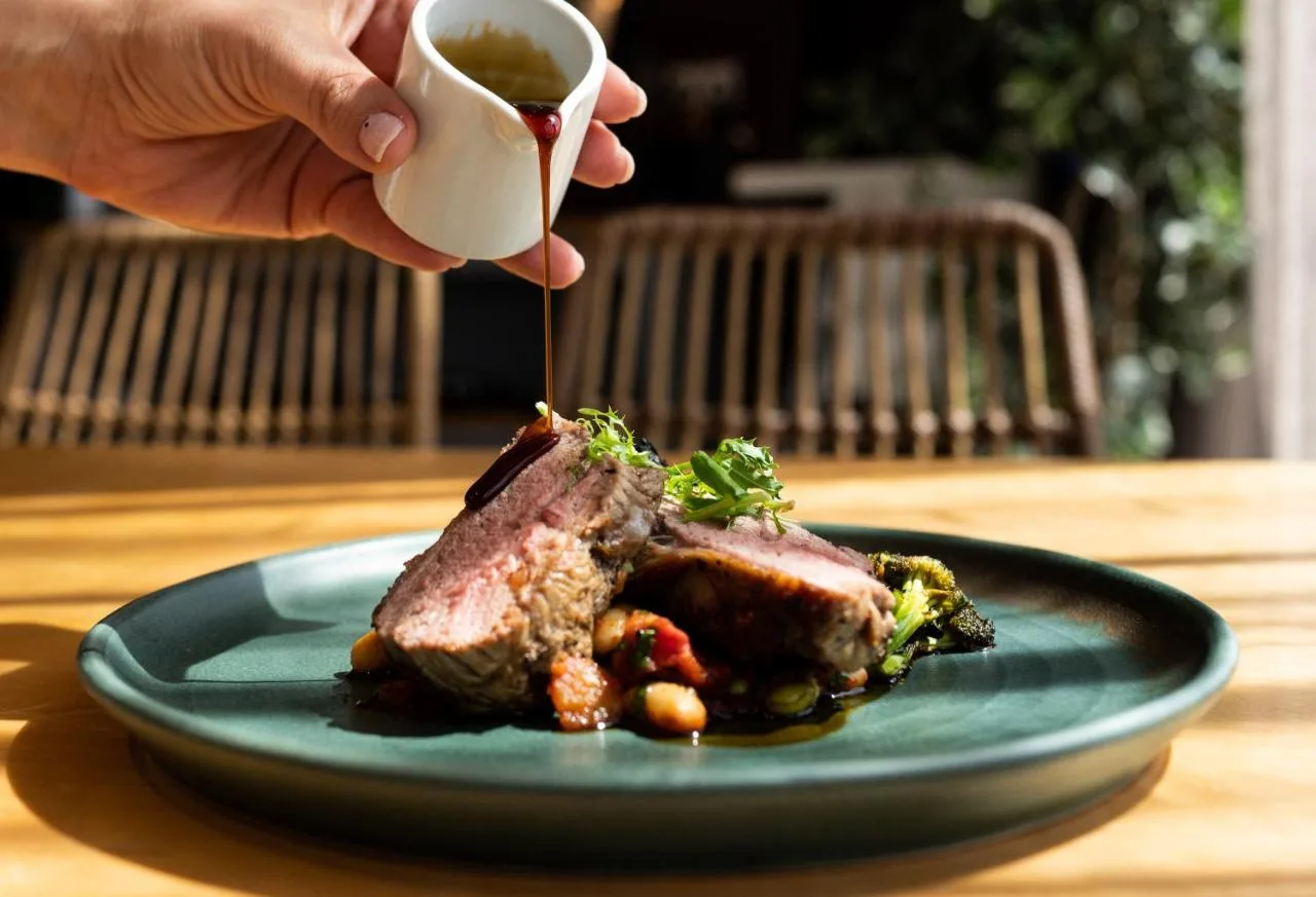 a person is holding a cup of tea next to a plate of food at Future Inn Cardiff Bay in Cardiff
